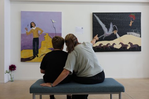 people sitting in front of paintings